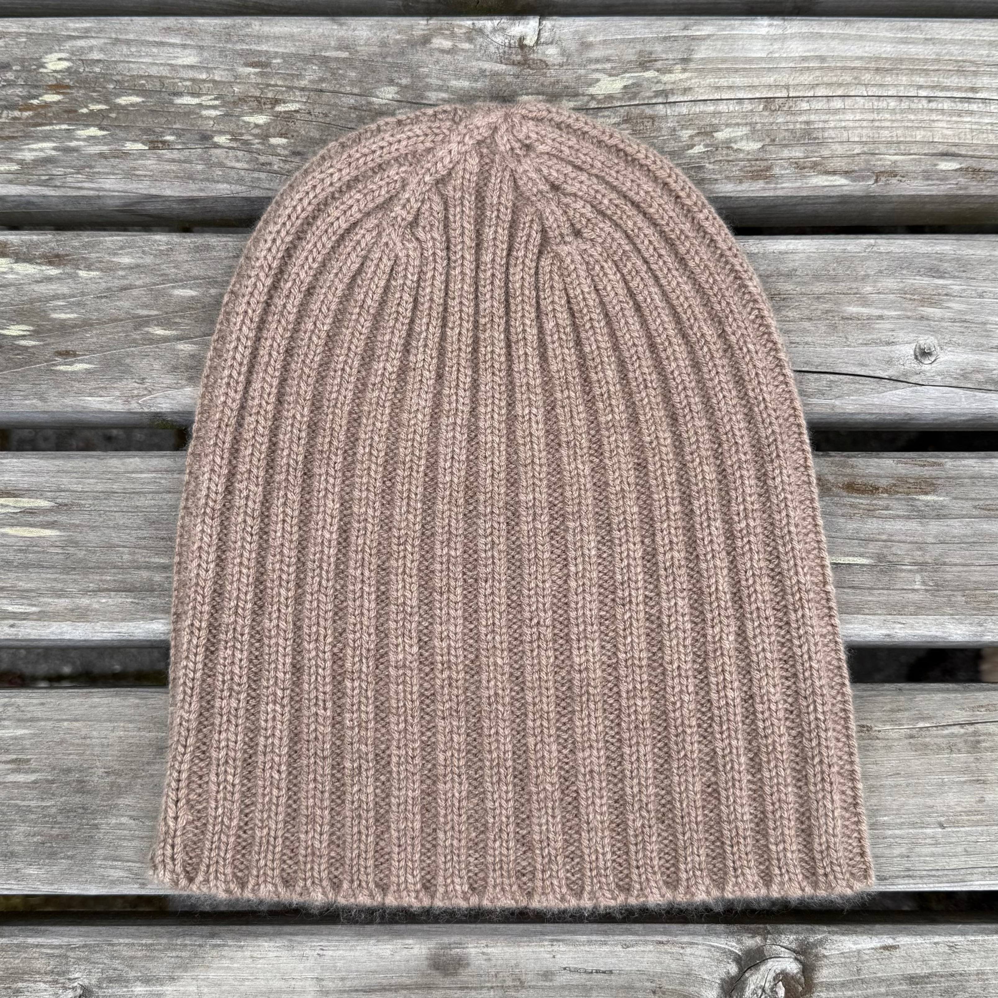 Brown knit beanie on a wooden surface
